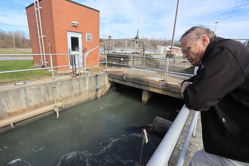 utility worker looking into a treatment plant.